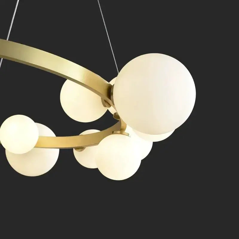 Simple chandelier by Simples Market: gold-toned rings with frosted white glass globes, multi-globe pendant light
