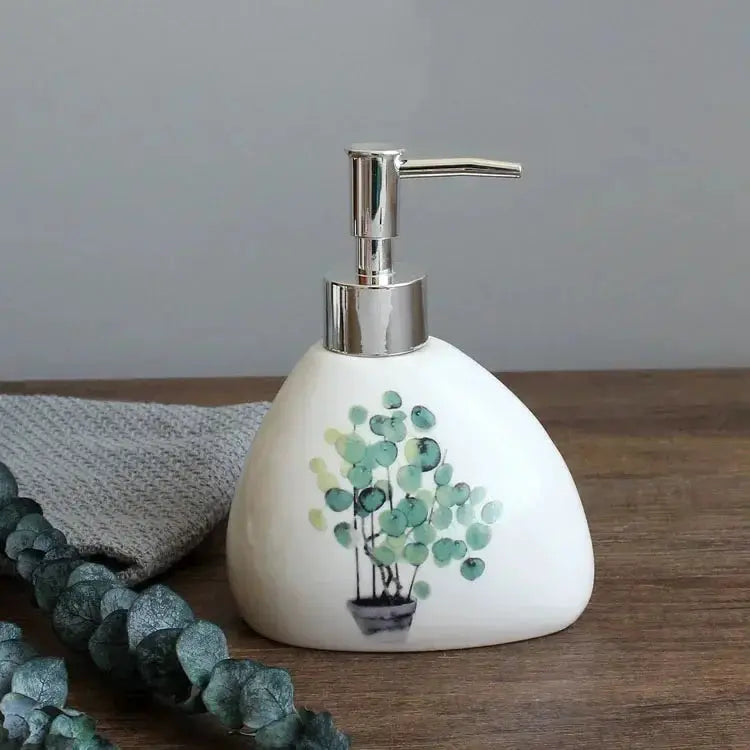 White ceramic soap dispenser with chrome pump and green plant design