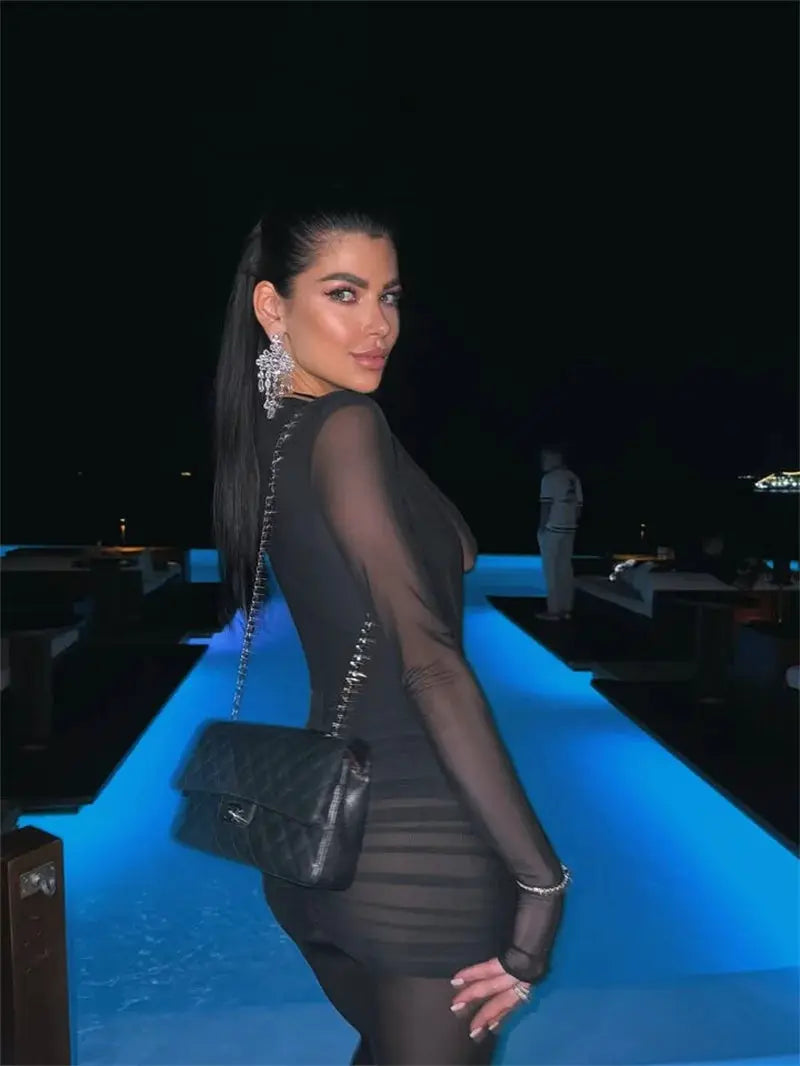 Mozision deep V-neck long-sleeve see-through ruched black jumpsuit with a quilted chain-strap handbag