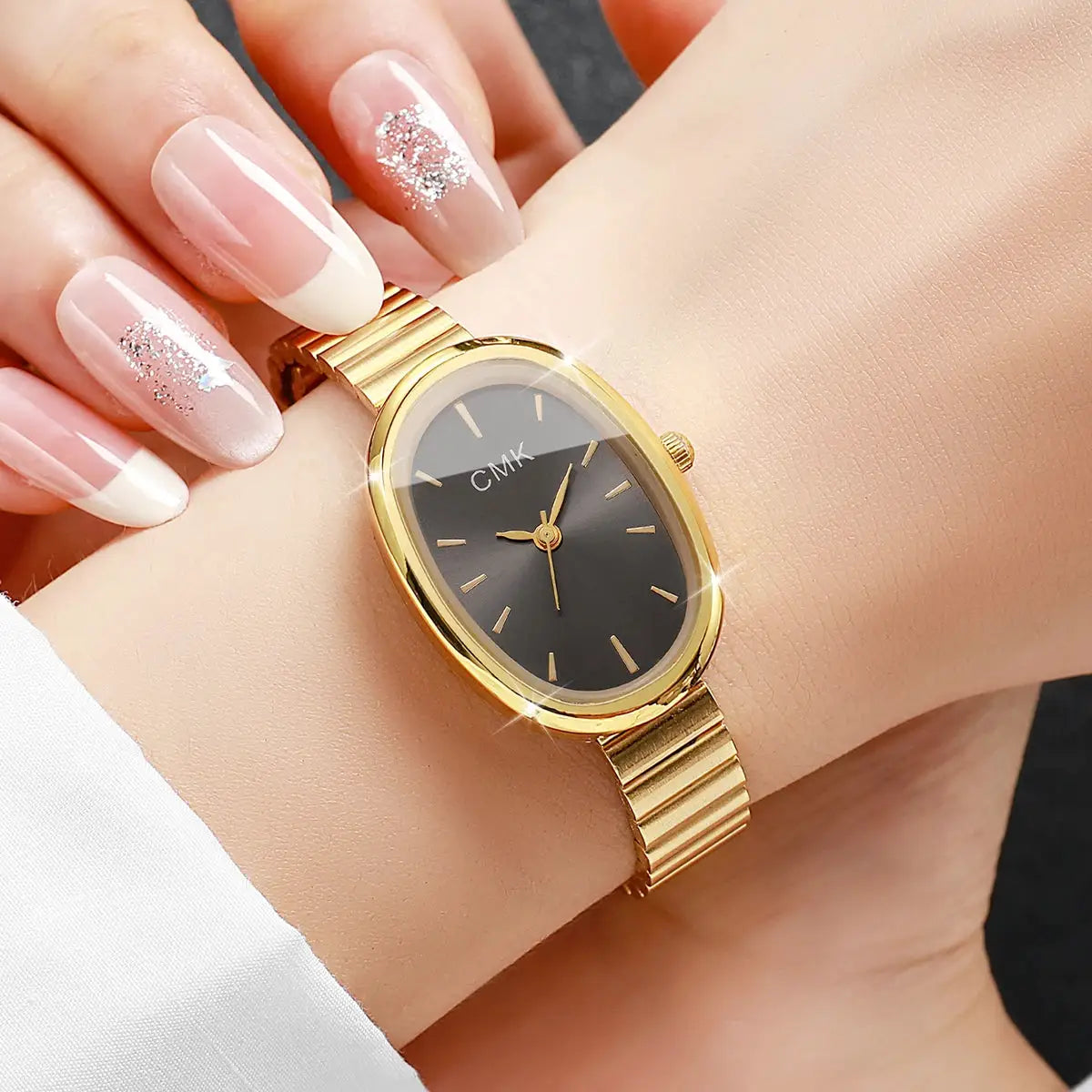 Women's fashion oval-dial watch with CMK on black dial and gold-tone case and bracelet
