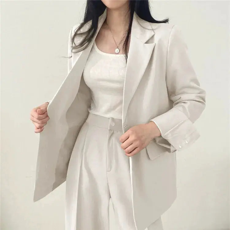 Beige blazer and matching pants two-piece set; long-sleeve, oversized tailored suit with notched lapels.