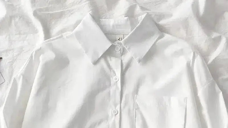 White women's oversized button-down shirt with chest pocket, turn-down collar, and long sleeves.