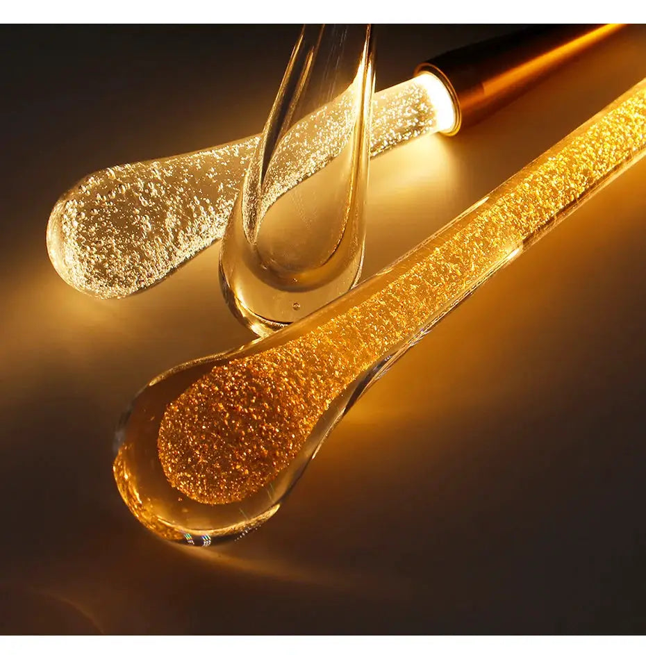 Crystal LED pendant lights with glass droplet shapes, warm golden glow for dining room or living area