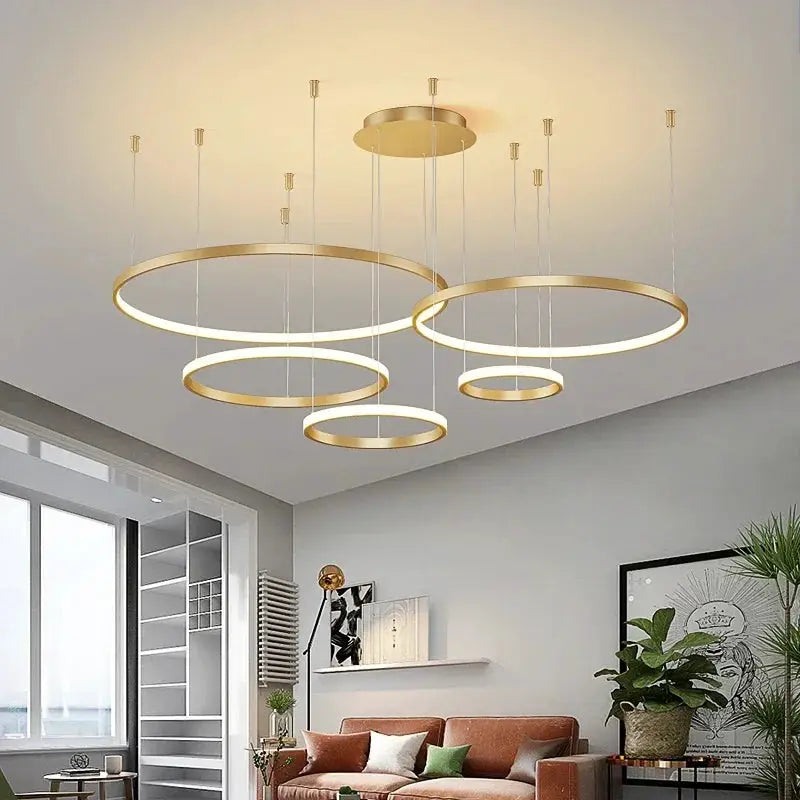 Minimalist ring pendant lights, five gold-tone acrylic LED rings for living room.