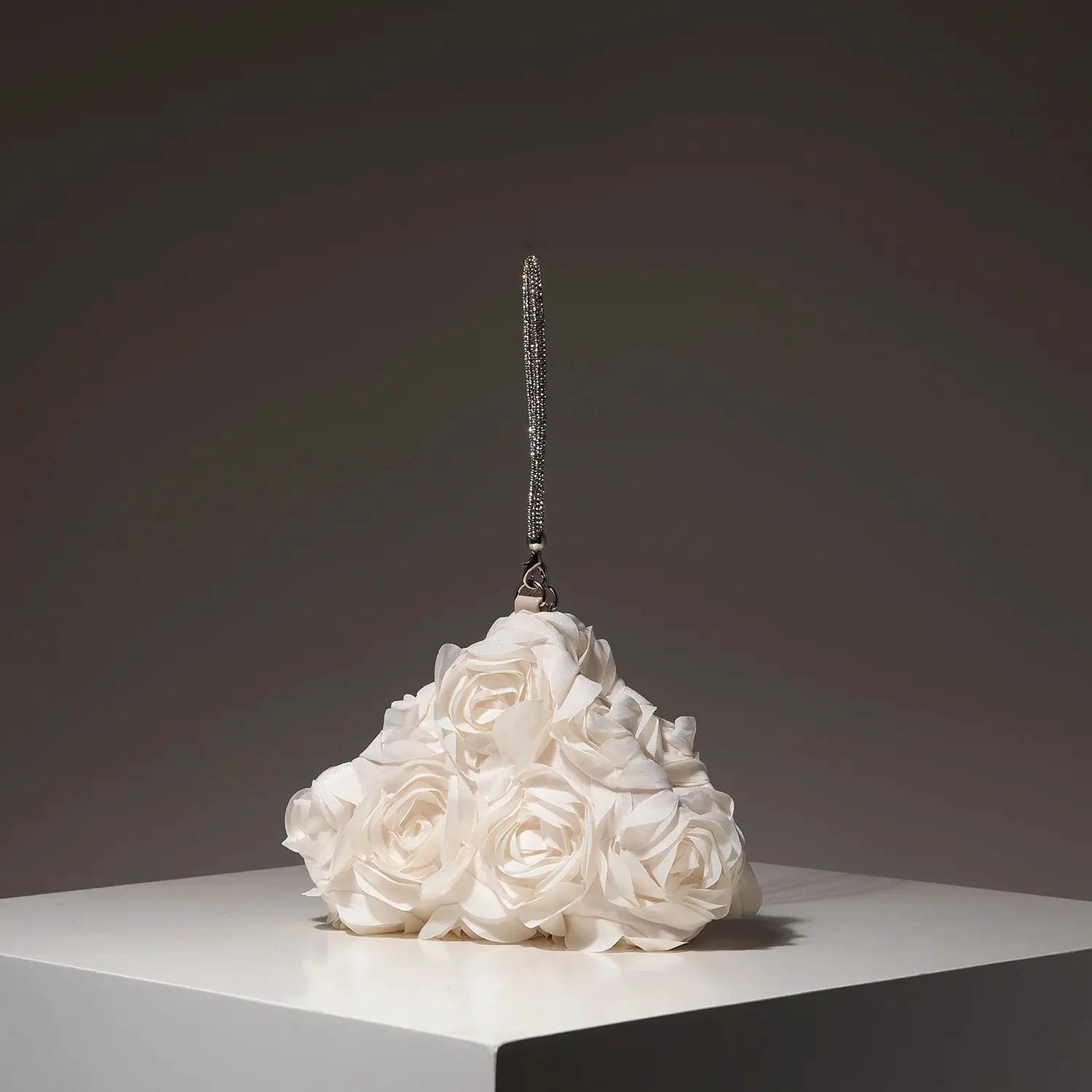 Mini bridal purse with silver beaded strap atop a white rose floral centerpiece