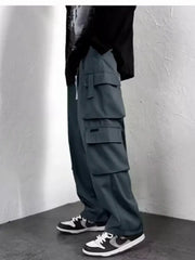 Men's blue-gray cargo jogger pants with multiple pockets and a baggy fit, shown with sneakers.