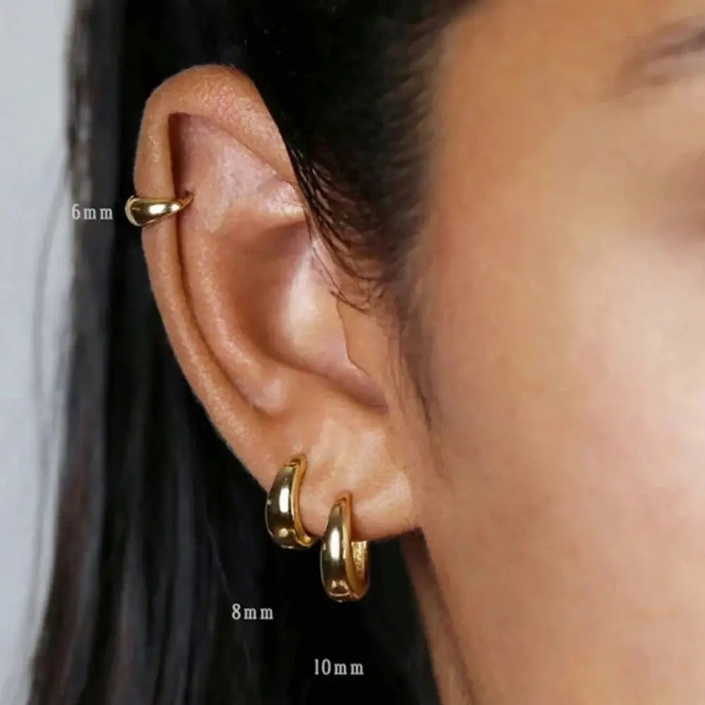 Gold-tone stainless steel hoop earrings set of three sizes (6mm, 8mm, 10mm) worn on ear