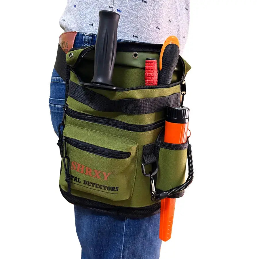 Metal detector finds bag, olive-green canvas pouch with multiple pockets and SHRXY branding