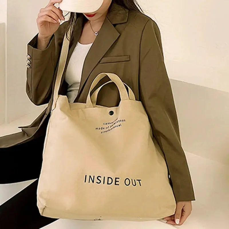Canvas tote bag in beige with INSIDE OUT print and dual handles, large capacity.