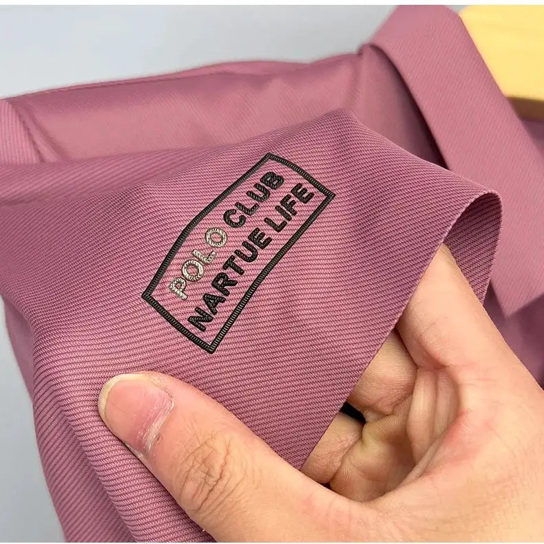 Men's pink ice-silk short-sleeve polo shirt with black embroidered sleeve patch.