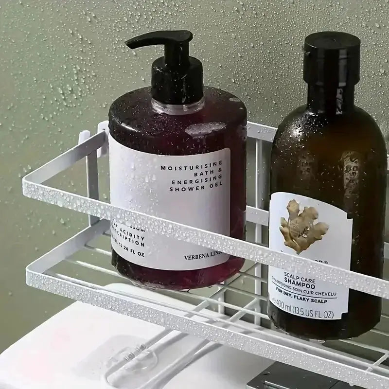 Bathroom over-the-toilet storage shelf; silver metal rack with two dark amber bottles (pump soap and shampoo).