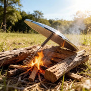 Solar Lighter outdoor fire ignition tool with metal parabolic reflector and coiled igniter over wood logs
