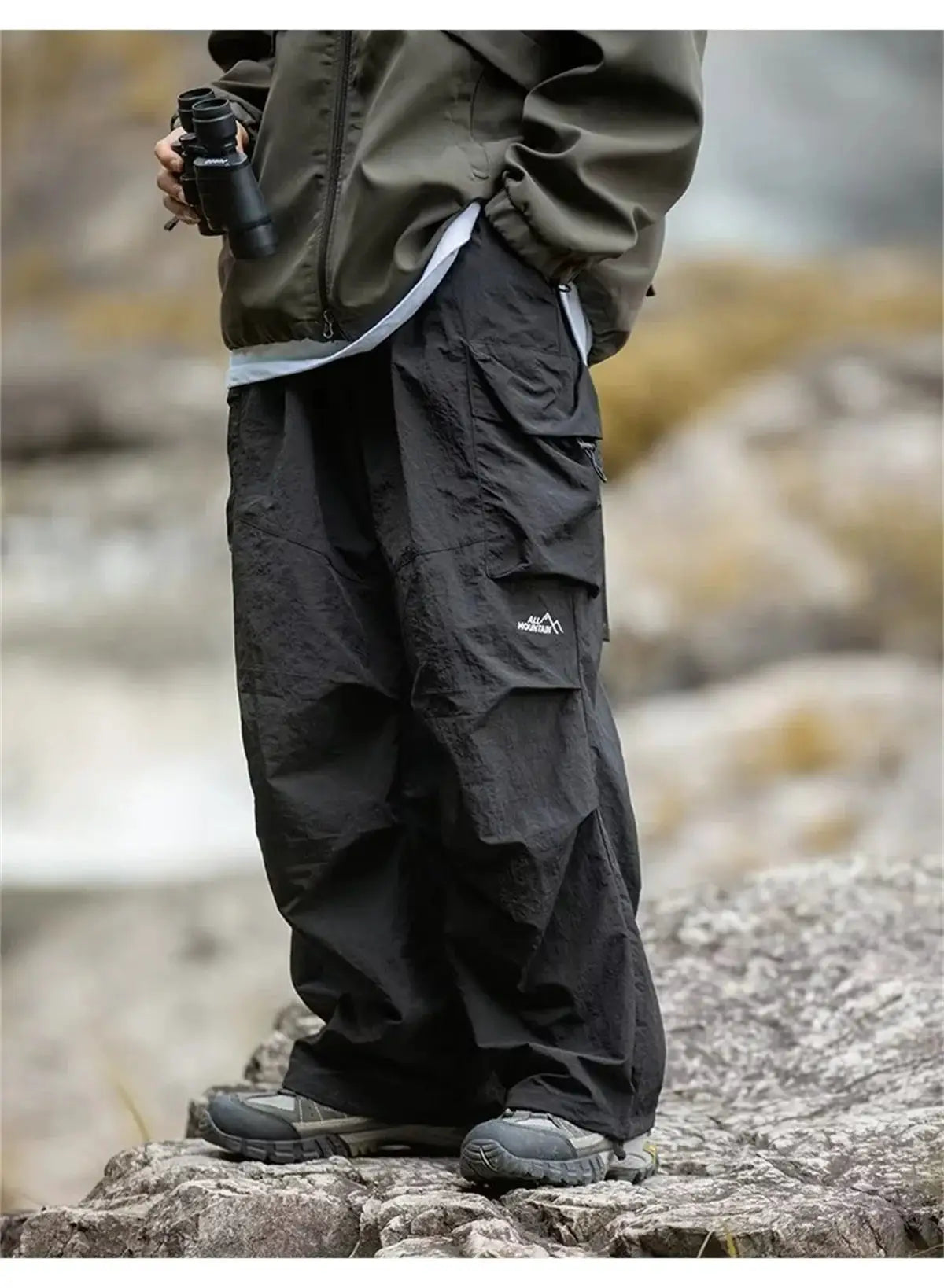 Men's black waterproof cargo hiking pants with multiple pockets and All Mountain logo
