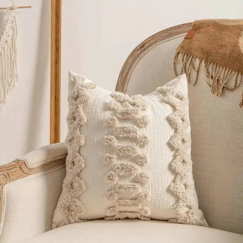 Beige bohemian-style throw pillow case with textured fringe trim along the edges on a light sofa