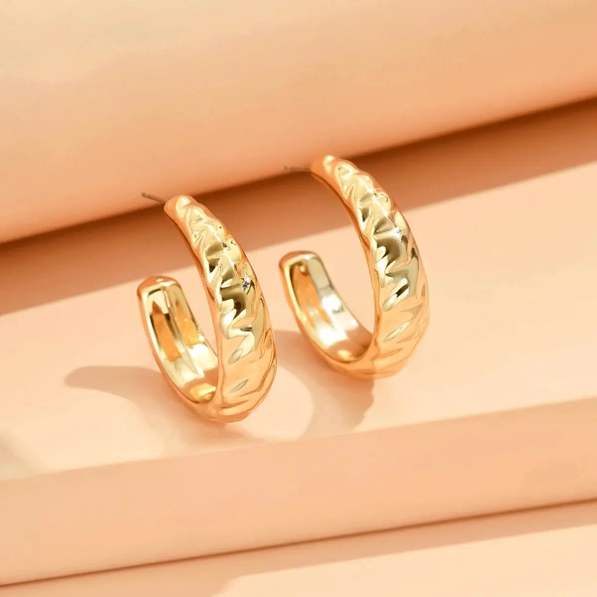 Pair of gold-tone geometric irregular hoop earrings with hammered texture