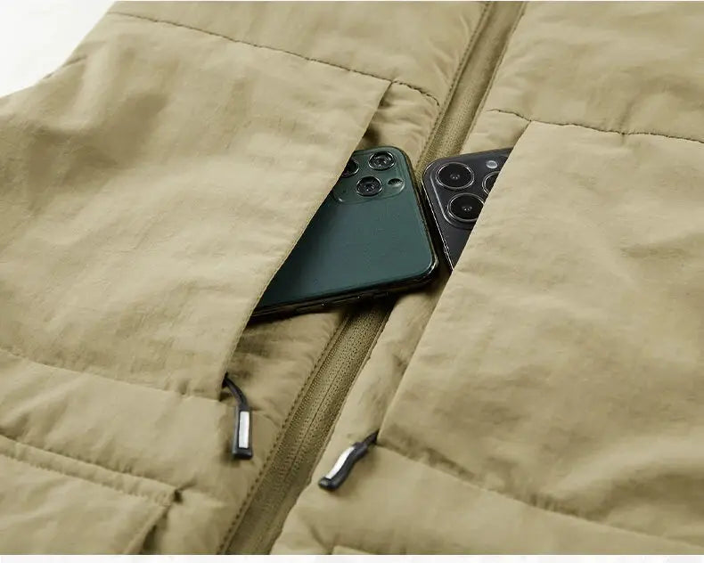 Beige quilted sleeveless vest with multiple pockets; two smartphones tucked into zip pockets