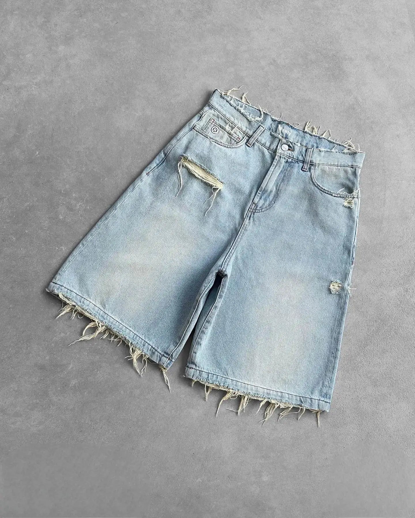 Distressed denim shorts, light wash with ripped hole and frayed hem