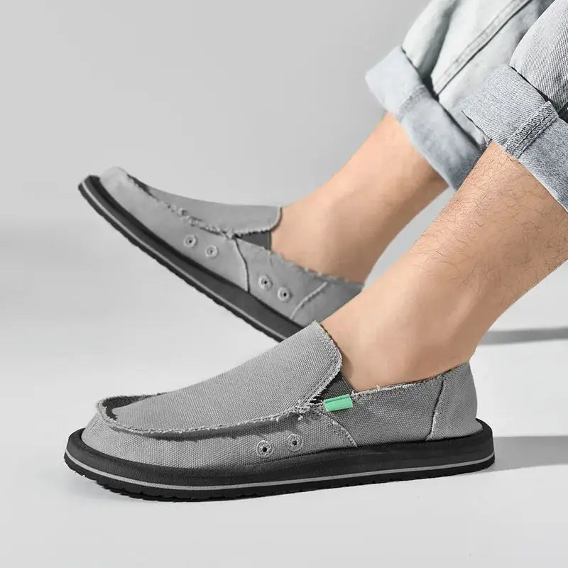 Pair of grey canvas loafers for men, breathable low-top casual sneakers with black sole.