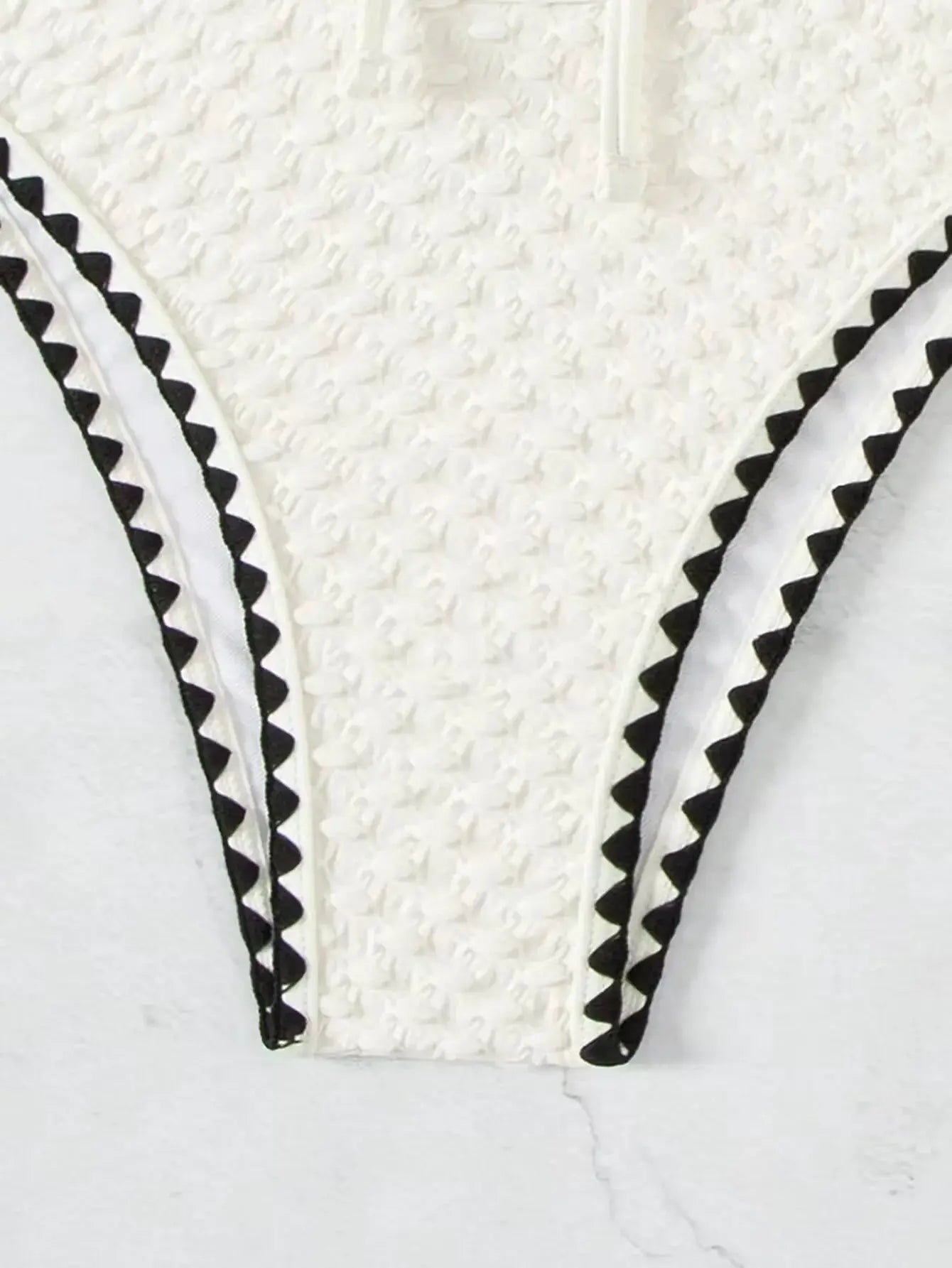 Bikini top, white textured fabric with black zigzag trim