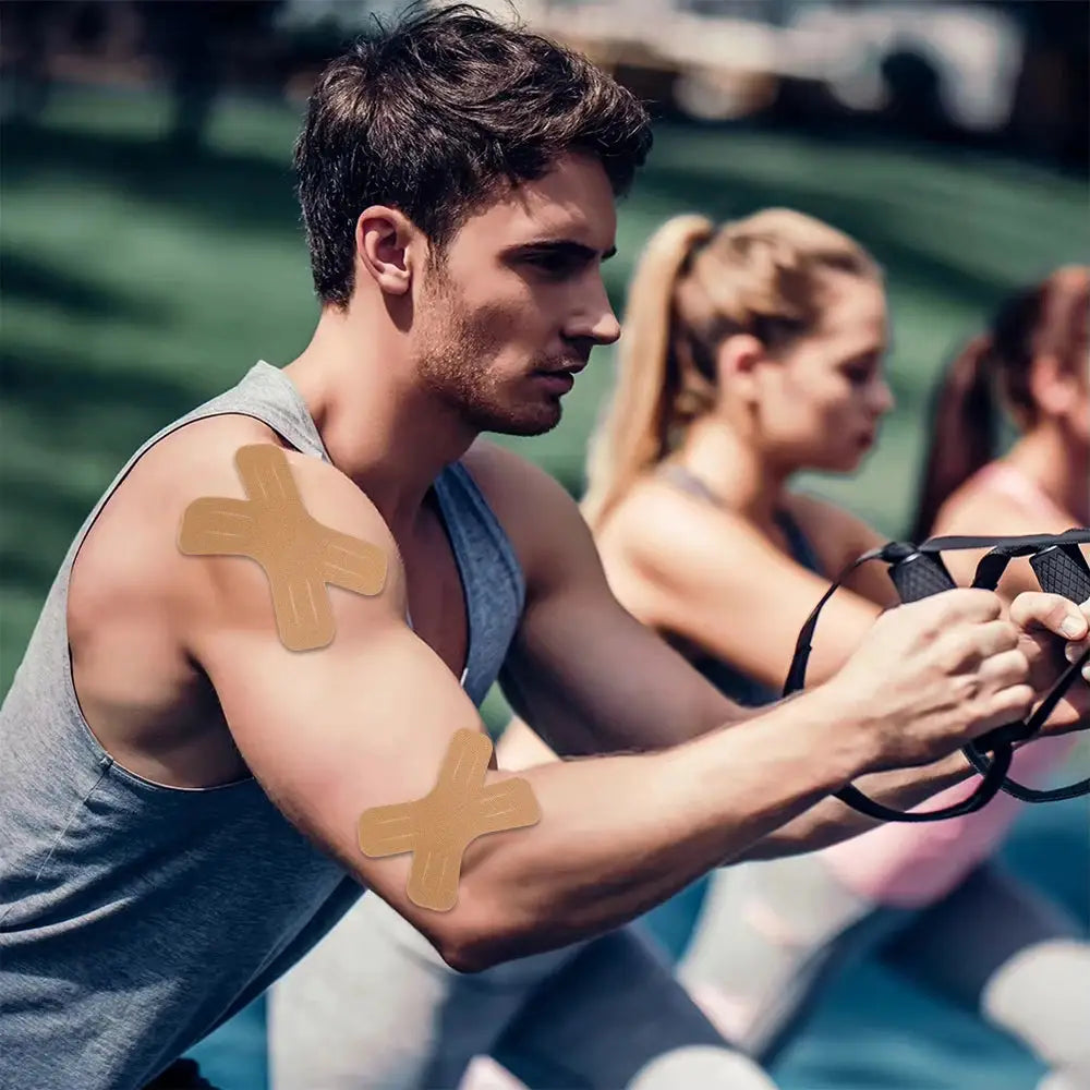 Kinesiology tape elastic therapeutic sports tapes; two beige patches on shoulder and elbow during outdoor workout.