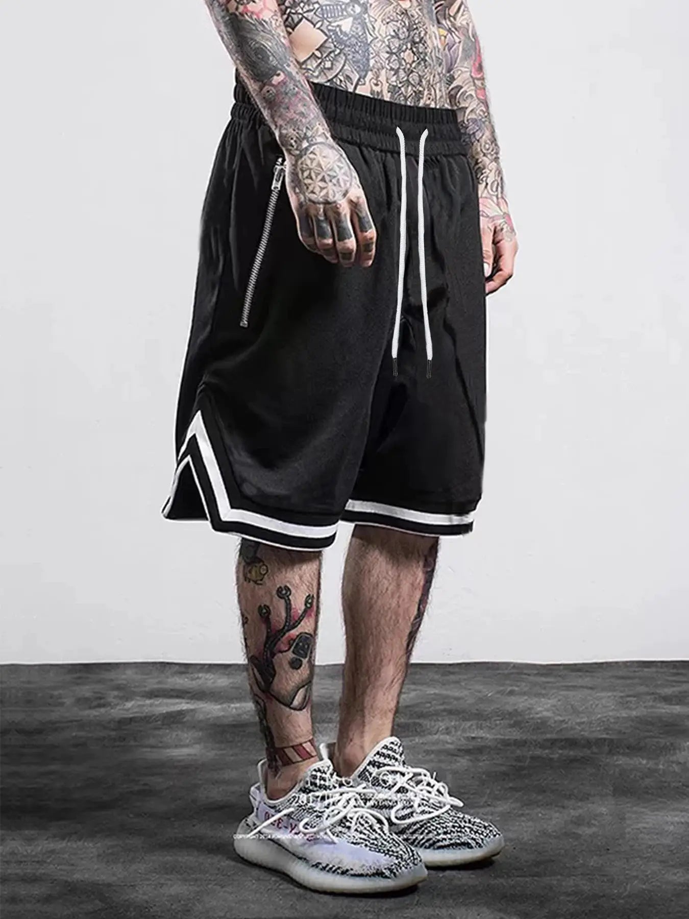 Men's black mesh quick-dry basketball shorts with white drawstrings, white piping at hem, and zip pocket
