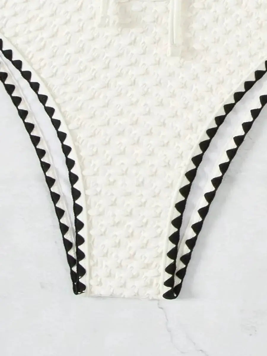Bikini set white textured bandeau with black zigzag trim.