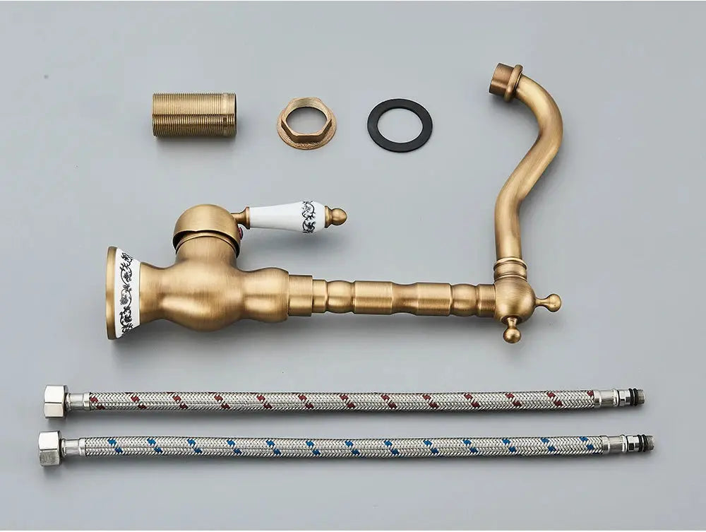 Antique brass bathroom faucet with curved rotating spout and ceramic handles, plus two braided hoses