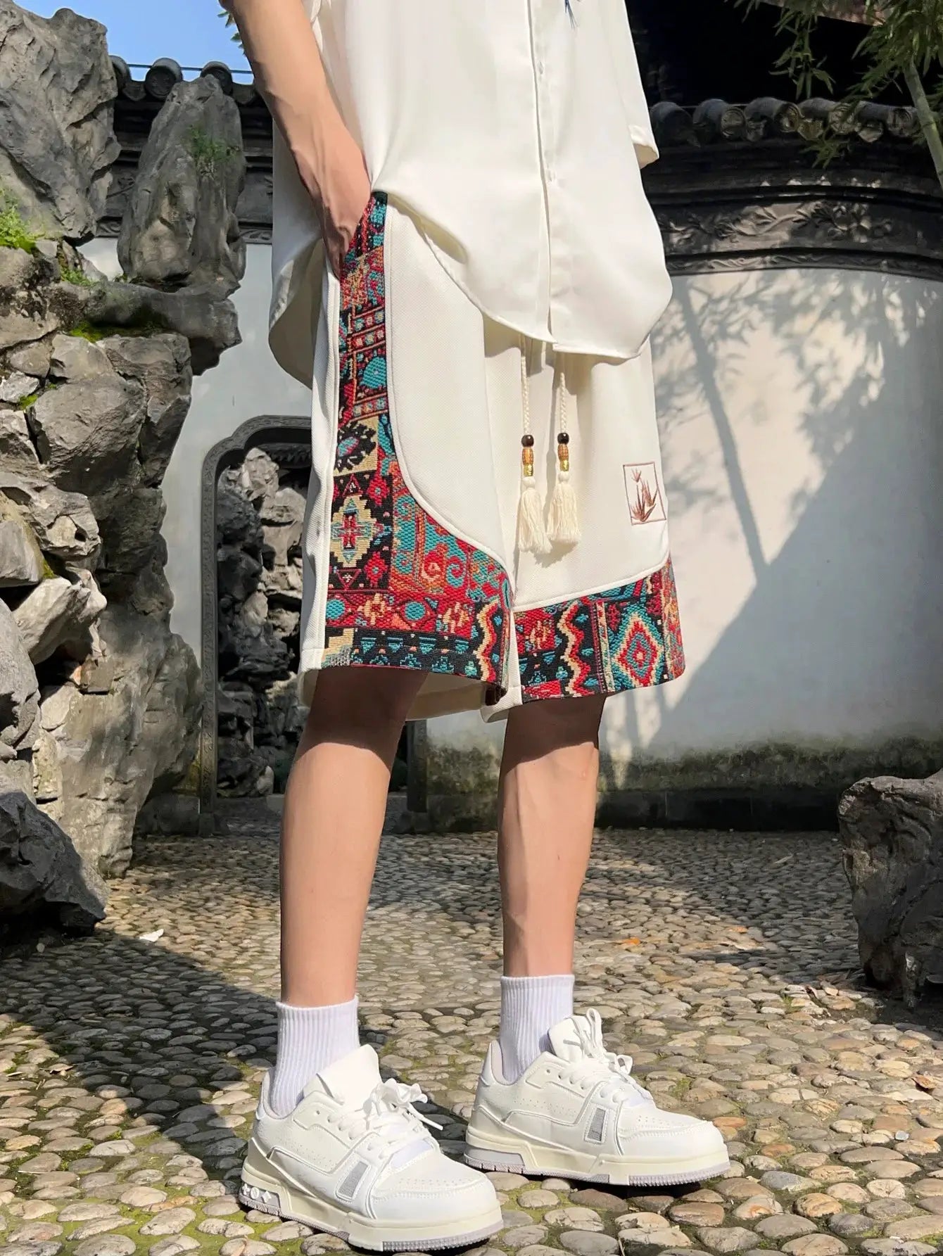 Men's ethnic embroidery shorts with pockets, cream base with colorful geometric side panels and drawstring tassels