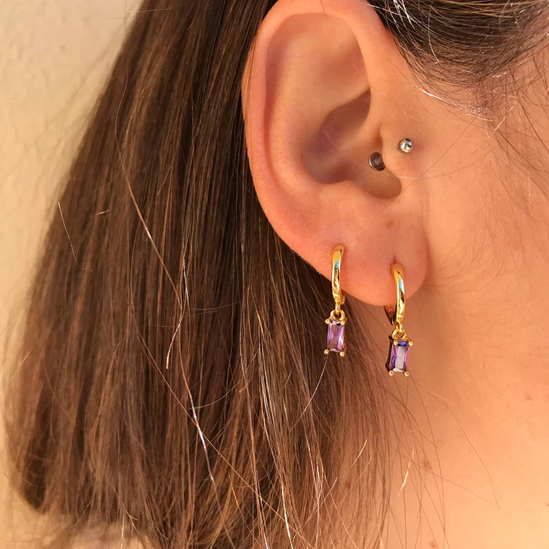 Gold-tone hoop earrings with purple rectangular zircon pendants, pair