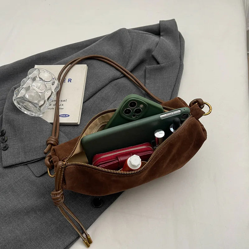 Simples Market brown faux suede shoulder bag with crossbody strap, open to show green smartphone and red zip pouch.