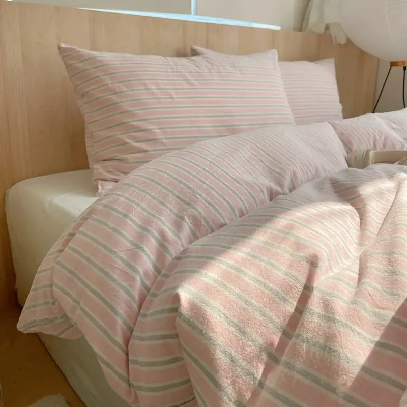 Pink striped 100% cotton duvet cover set with pillowcases on bed