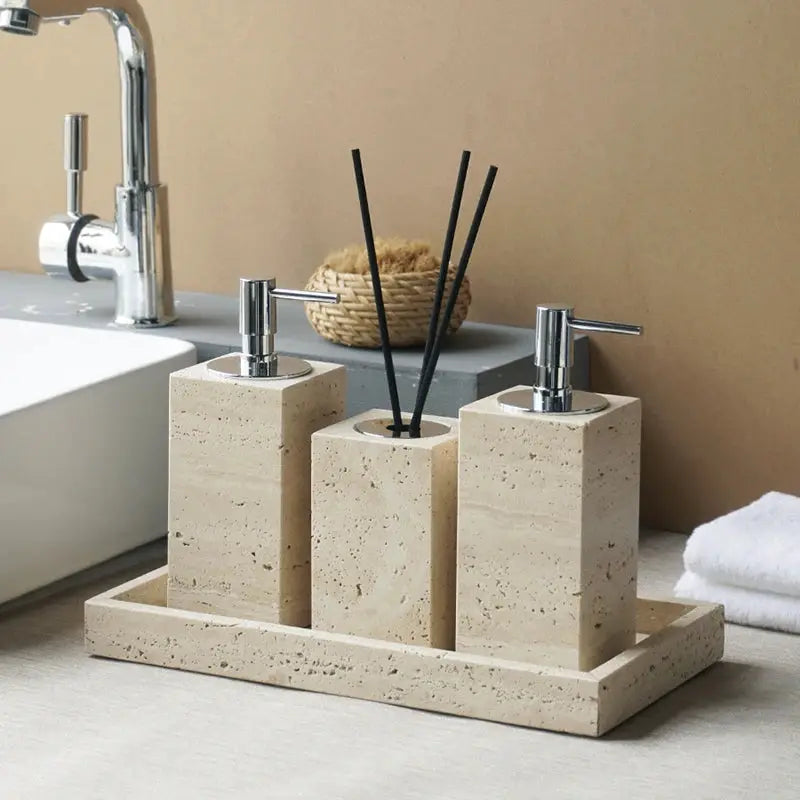 Beige travertine bathroom accessories set 3-piece with soap dispenser, soap dish, and reed diffuser on a tray