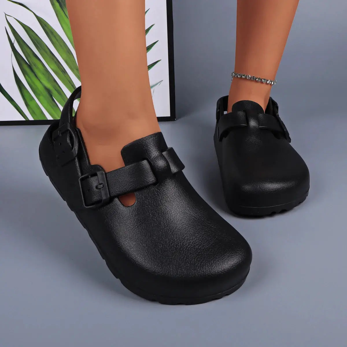 Pair of women's black platform buckle clogs; slip-on casual footwear