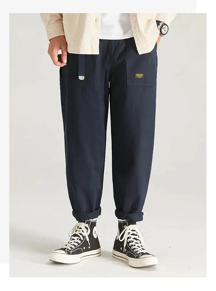 HIQOR navy cargo pants for men with multiple pockets, belt design, baggy fit, and rolled cuffs.