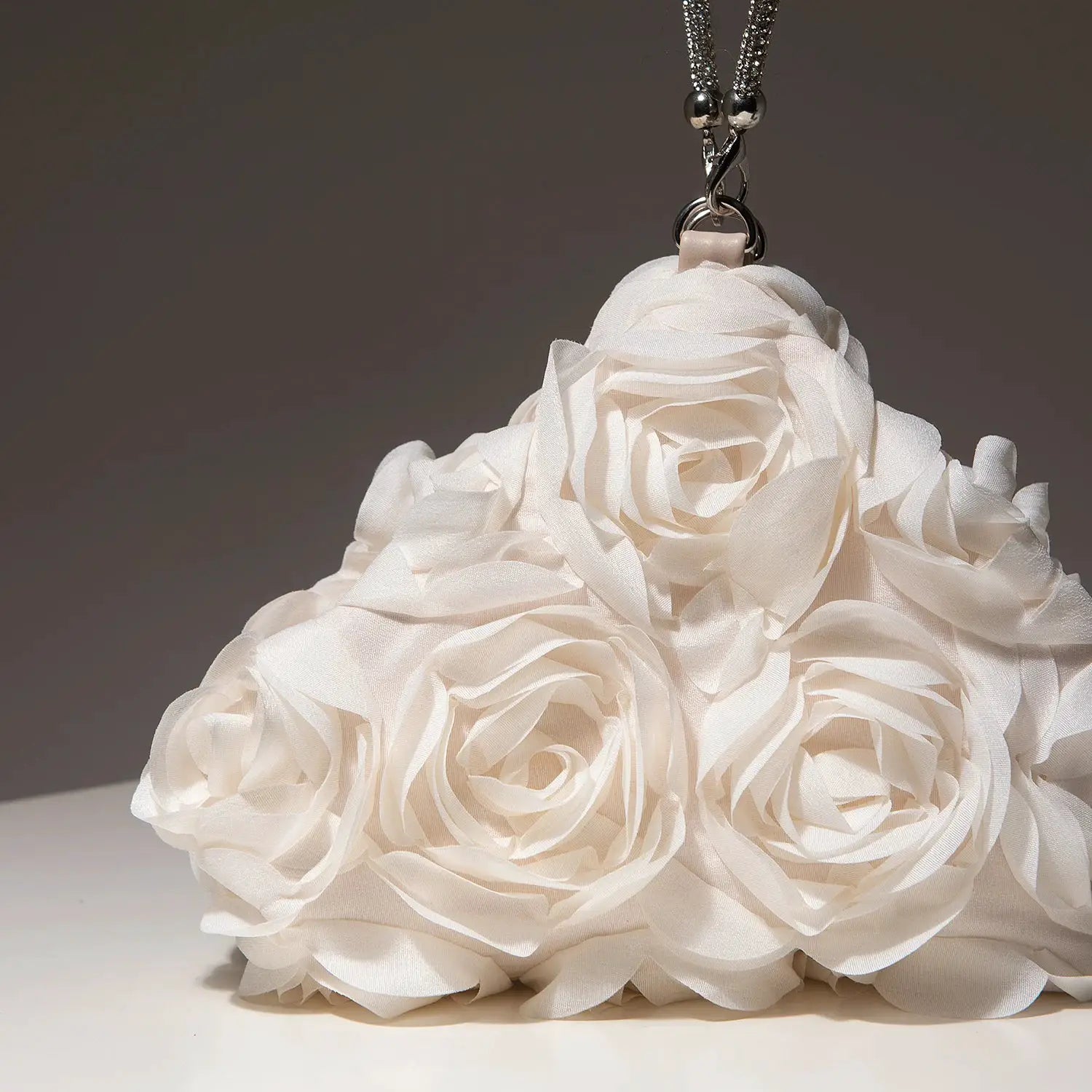 Mini floral white purse with rose-shaped fabric petals and a silver chain