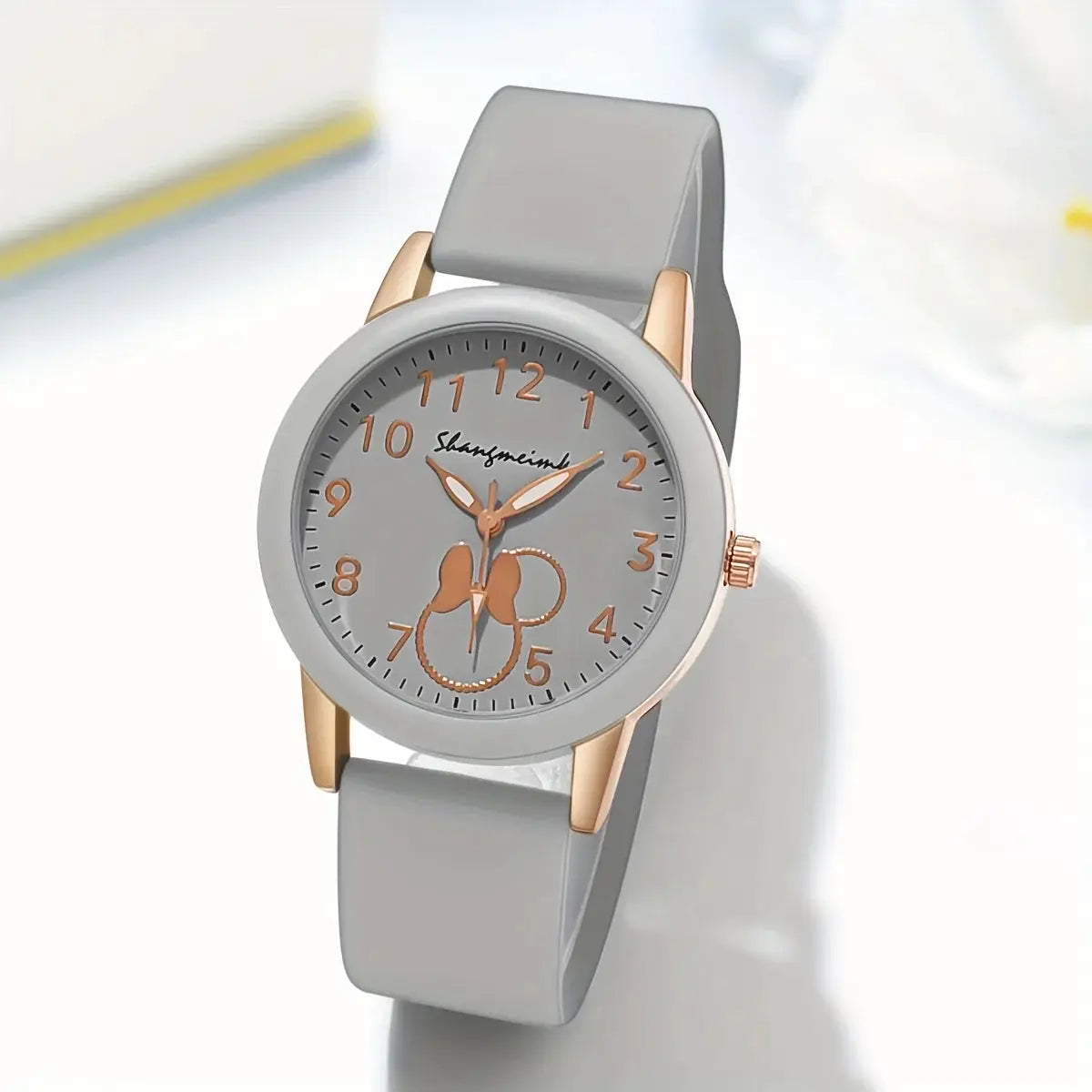 Casual round women's quartz watch with gray silicone strap, rose-gold case and copper-tone numerals.
