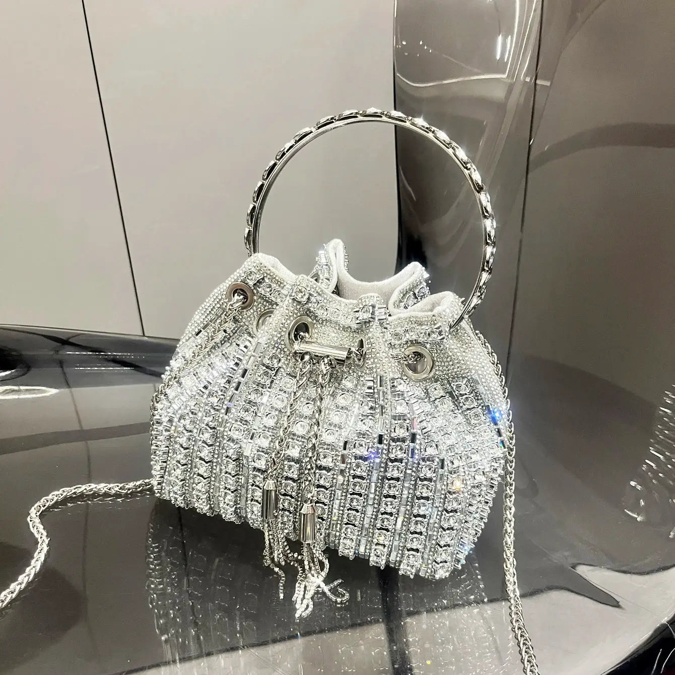 Crystal rhinestone bucket bag with a silver circular handle by Simples Market, evening clutch.