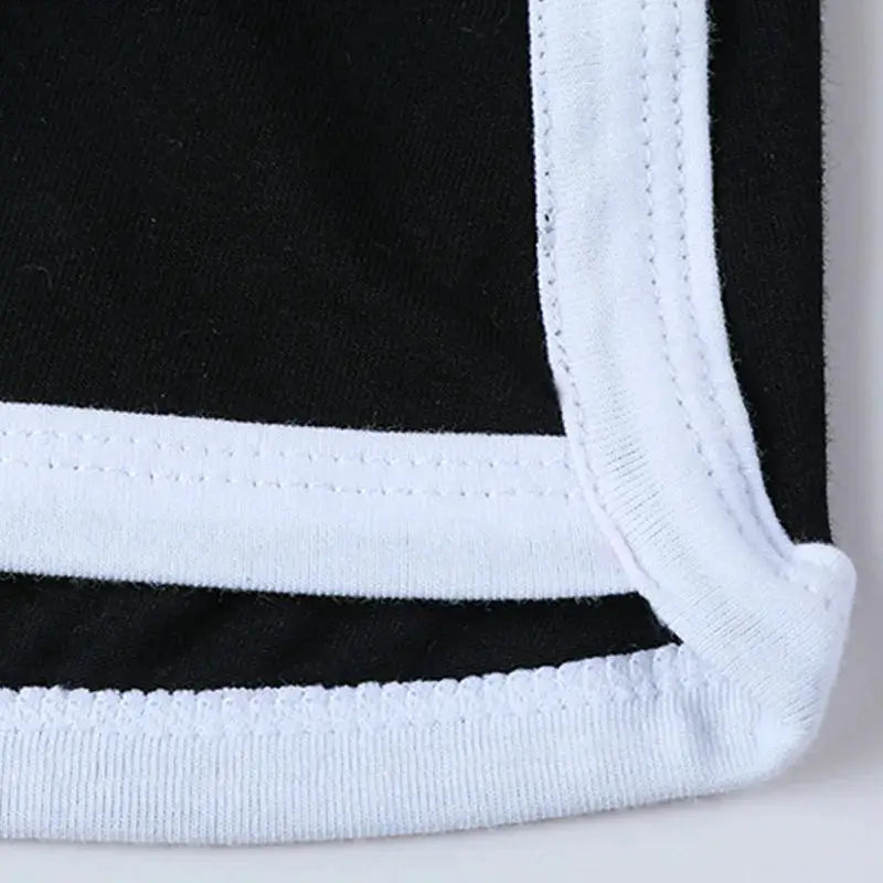 Women's low-waist boxer briefs in black with white trim, close-up of hem and waistband stitching details.