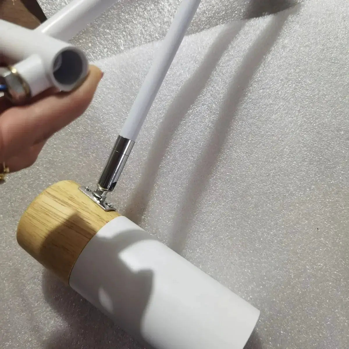 Modern rocking arm wall lamp by Simples Market; white metal with natural wood base, telescopic foldable reading light