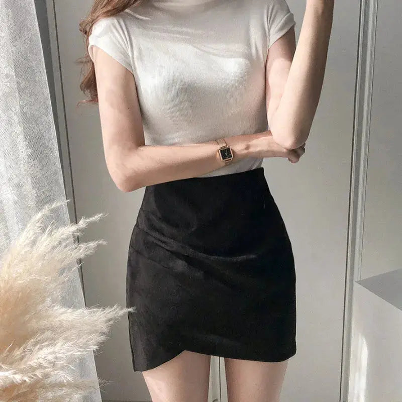 Mini skirt, black high-waisted, simple solid color, paired with a white top.