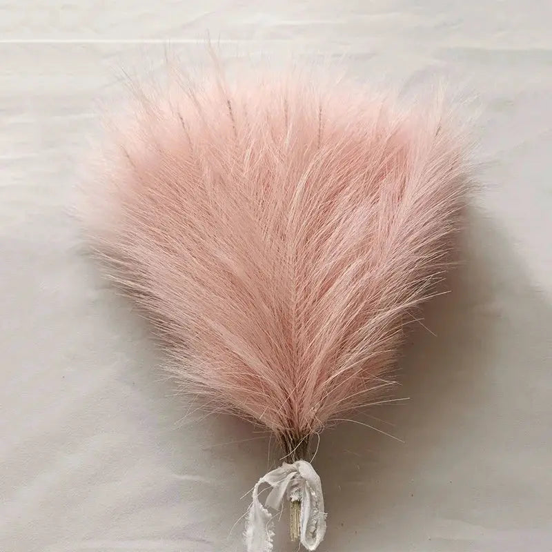 Pink pampas grass bouquet for boho decor, fluffy plume tied with ribbon.