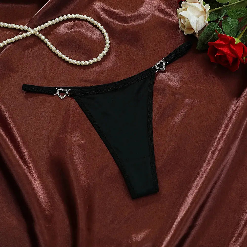 Thong by Simples Market, black low-rise with heart crystal decorations.