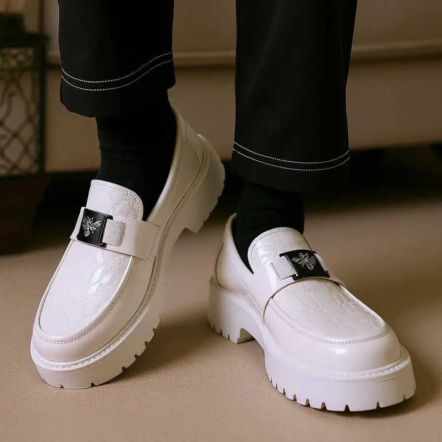 Pair of men's white leather slip-on loafers with bee-design strap and chunky sole