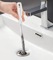 Pipe dredging brush for sink drains with white plastic handle and flexible bristle coil