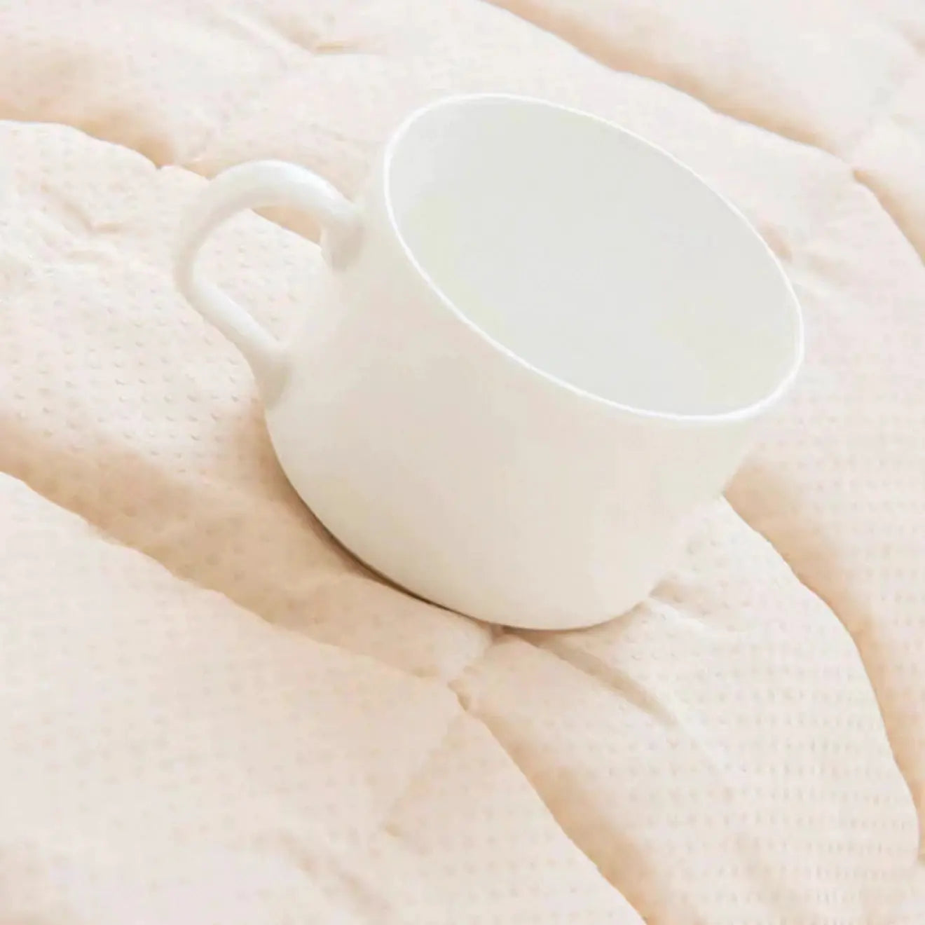 Simples Market Thicken Quilting Warm Stripe Flannel Sofa Pad, ivory quilted surface with a white mug