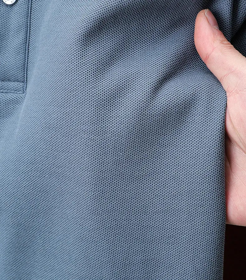 Blue cotton polo shirt close-up fabric with a hand holding and a visible button