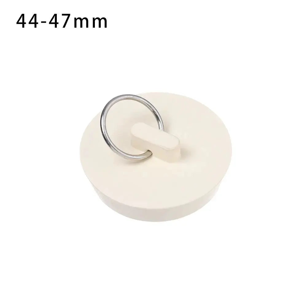 White rubber sink drain plug with metal ring and lift tab, fits 44–47 mm.