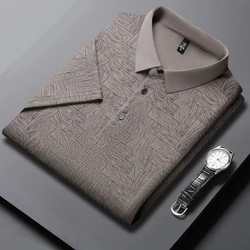 Men's polo shirt with abstract print in taupe, folded with beige collar and short sleeves.