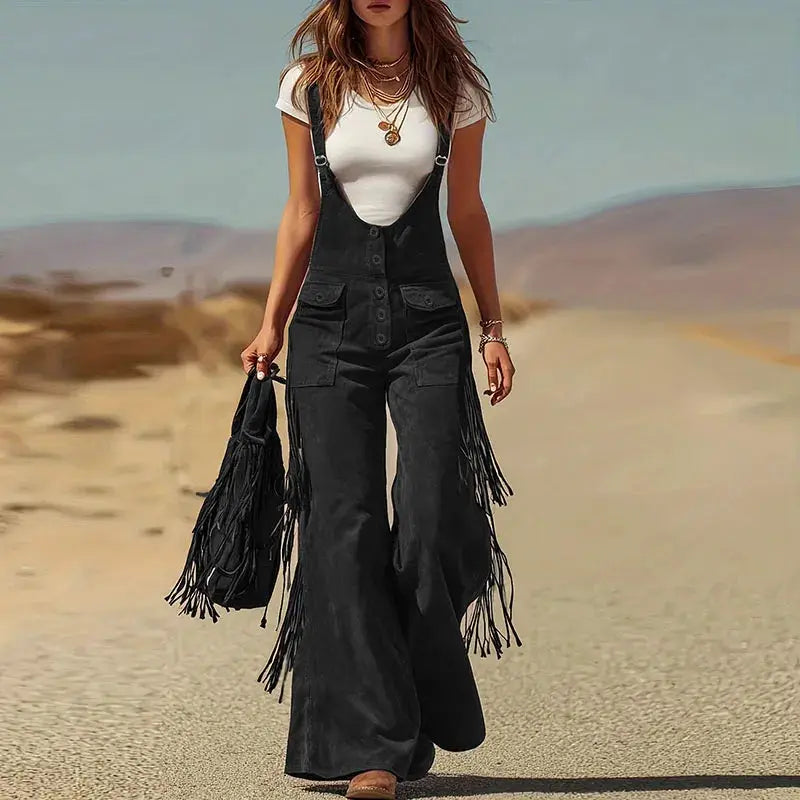 Overalls with fringe tassels, black suede-like fabric, wide-leg, button-front bib with straps.