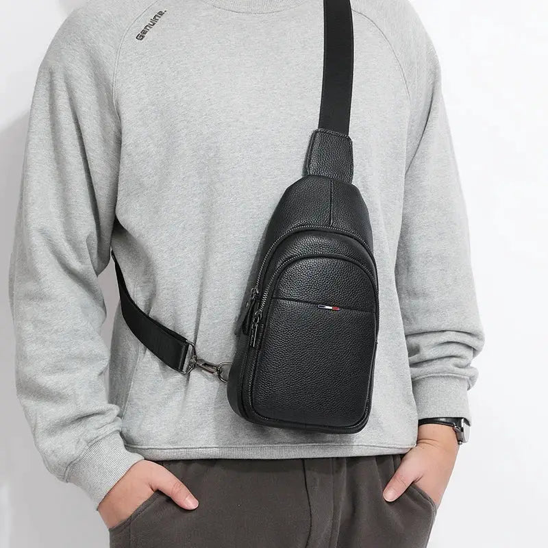 Black genuine leather men's chest bag with pebbled texture, compact crossbody sling with front zip pocket.